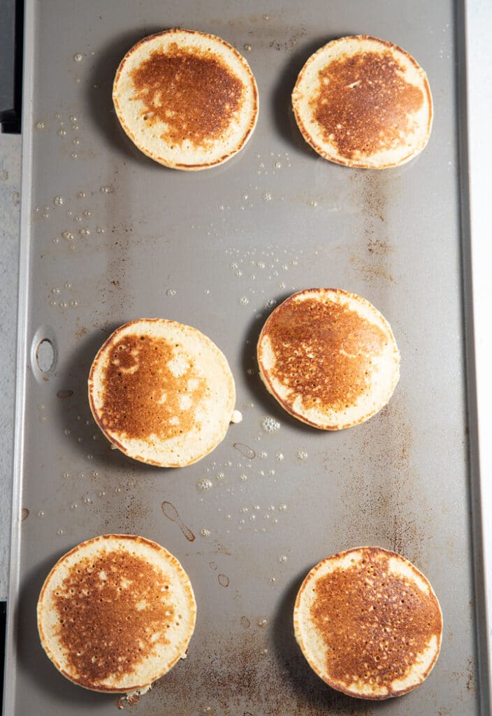 The flipped banana oatmeal pancakes on a griddle ready to serve