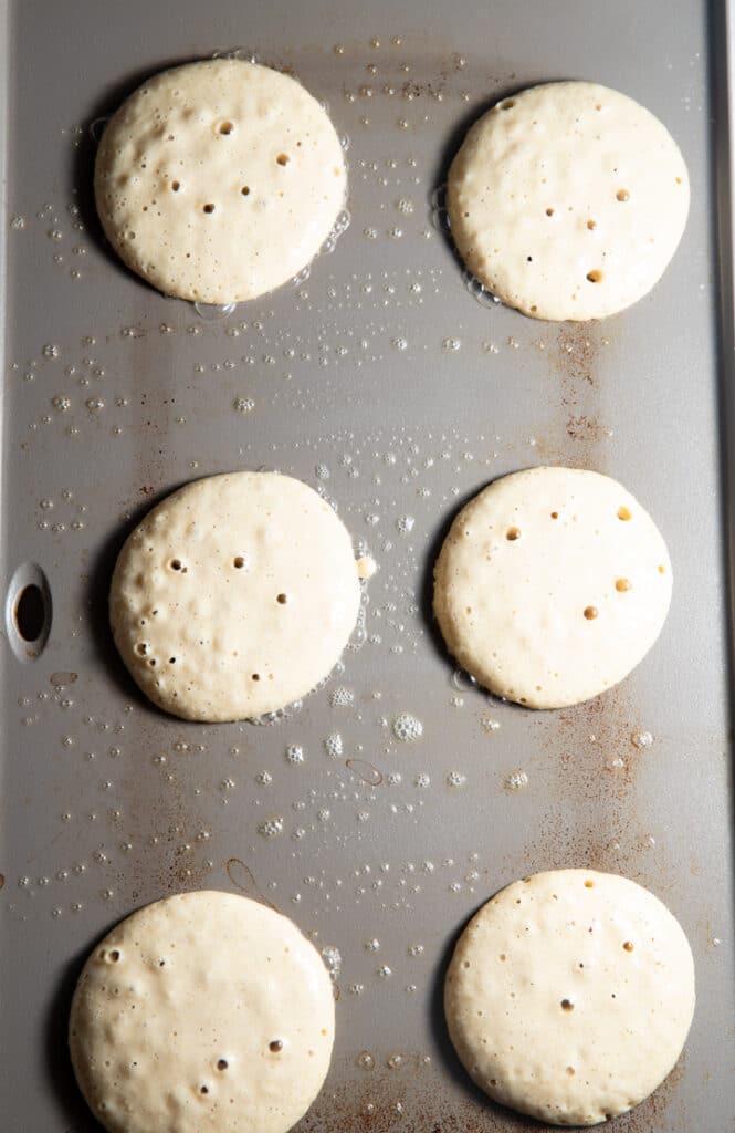 The pancakes on a griddle ready to be flipped