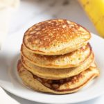 Banana oatmeal pancakes stacked on a white plate