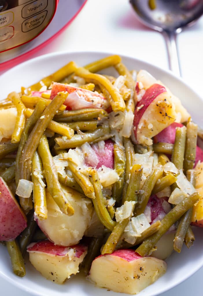 Instant pot green beans and potatoes served on a white plate