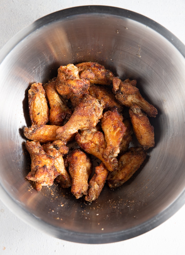Cooked jerk chicken wings in a silver bowl