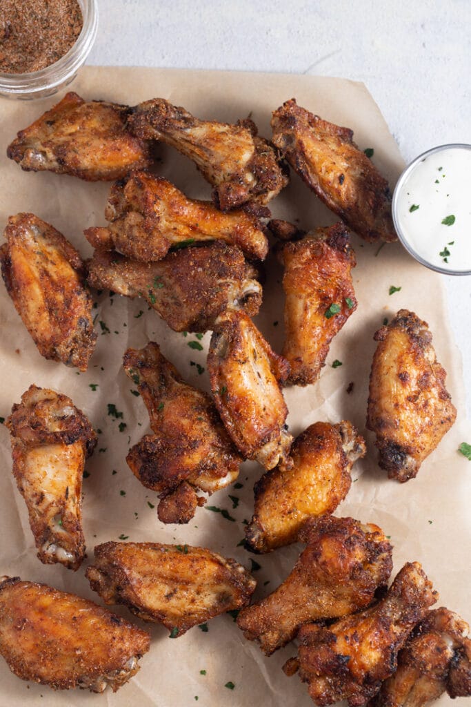 Jerk chicken wings on parchment served with a dip