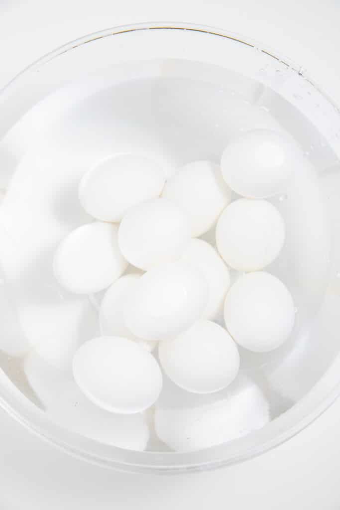 The boiled eggs in a bowl of water to cool