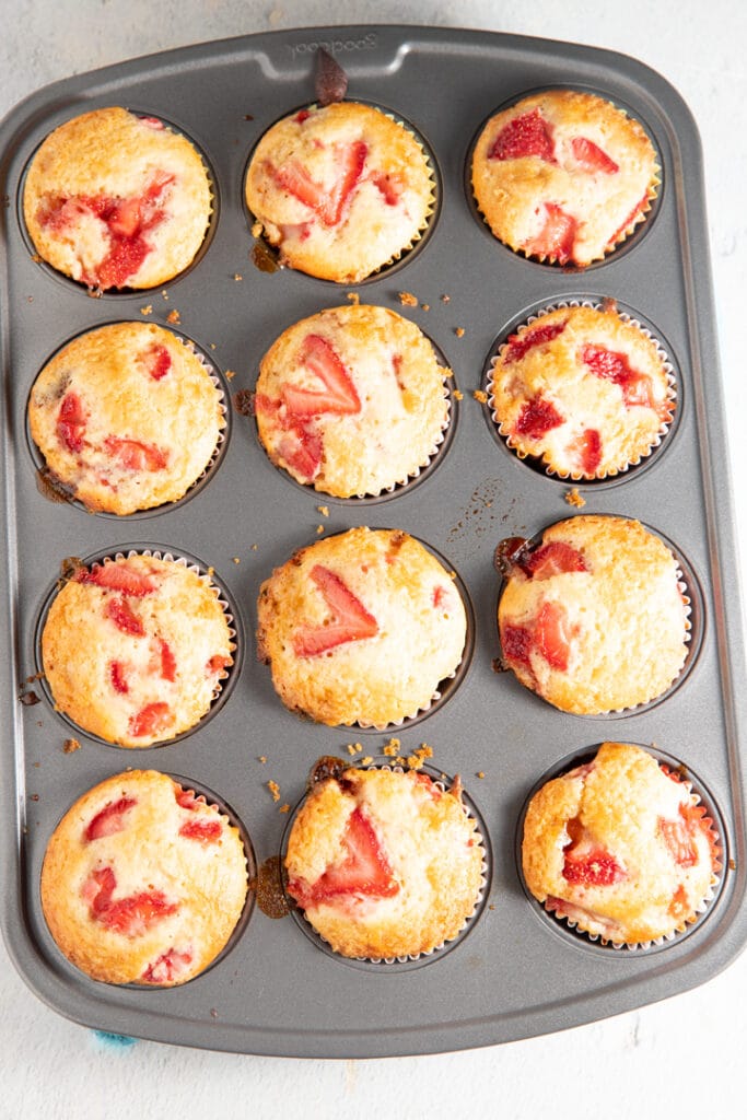 The baked strawberry muffins in a muffin tin