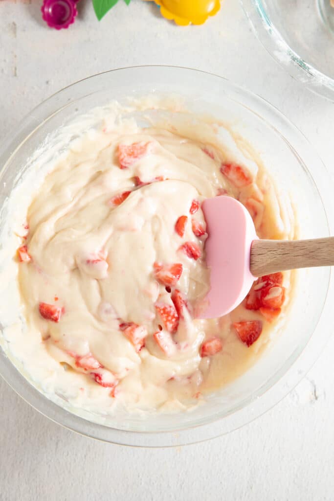 Strawberries being stirred into the muffin batter