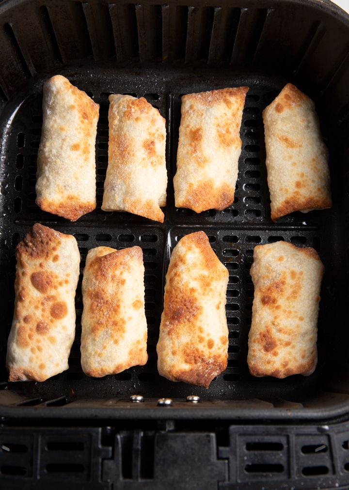 The cooked egg rolls in the air fryer basket