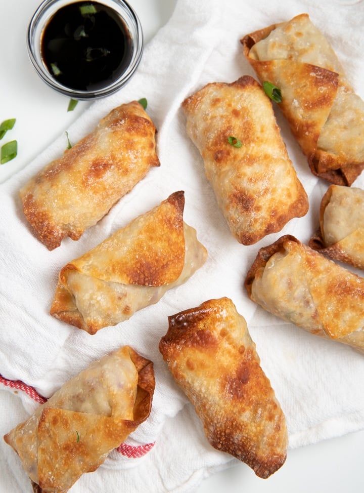 Air fryer egg rolls next to a dipping sauce