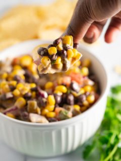 Black bean salsa being scooped with a chip