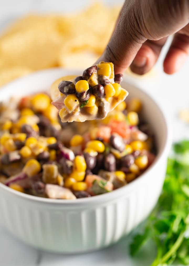 Black bean salsa being scooped with a chip