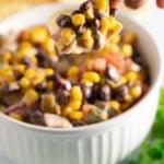 Black bean salsa being scooped on to a tortilla chip