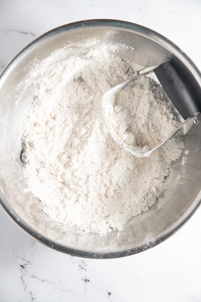 bowl with flour mixture with pastry cutter in it