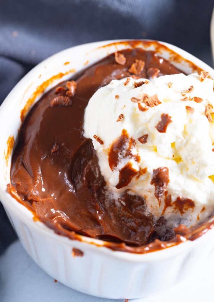 Homemade chocolate pudding topped with whipped cream and chocolate shavings