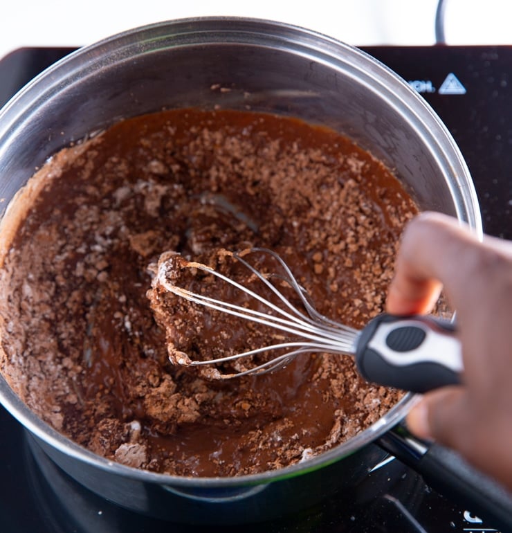 The cocoa powder dissolving in the pan
