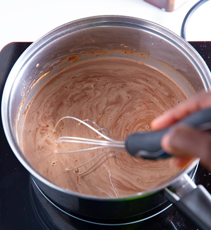 Milk being whisked into the cocoa powder and milk