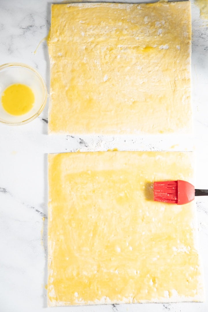 Egg being brushed on the puff pastry sheets