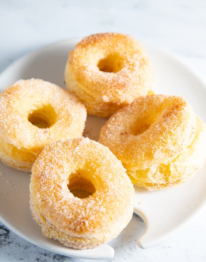 Four air fryer donuts on a white plate