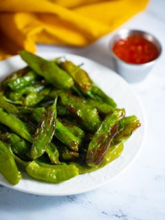 Air fryer shishito peppers in a white bowl