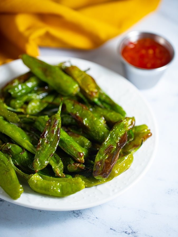 Air fryer shishito peppers in a white bowl