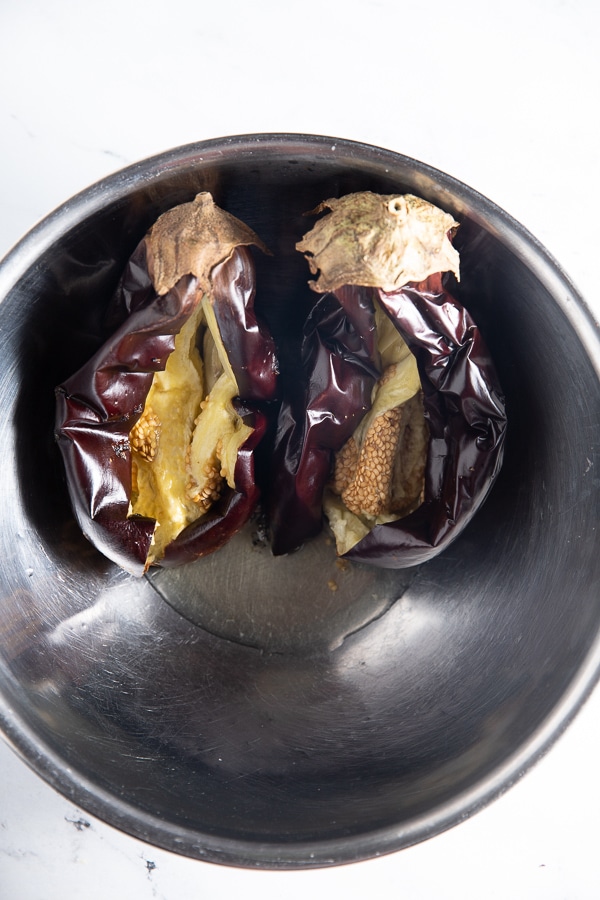 Roasted eggplant sliced open in a bowl