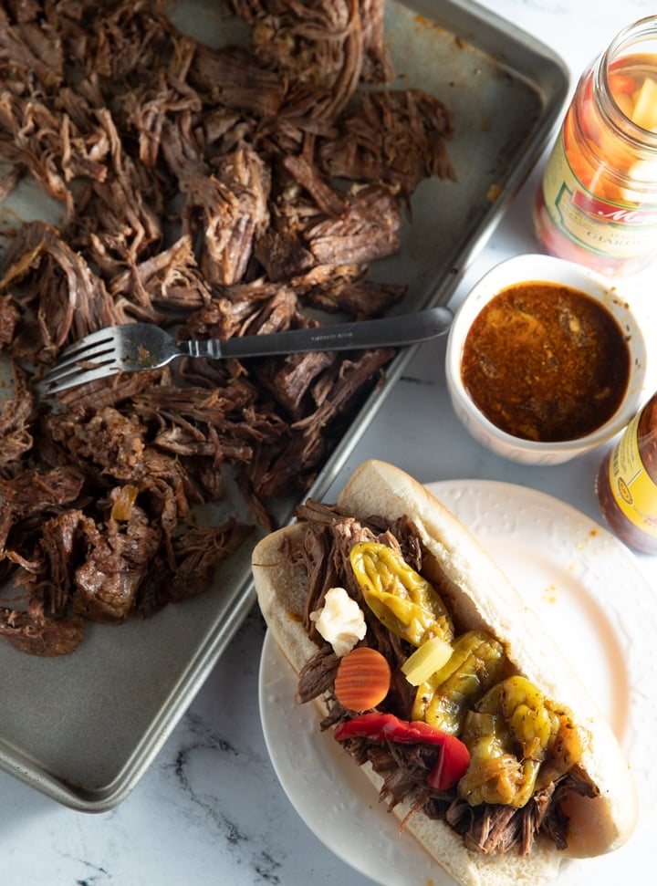 Italian beef on a baking sheet and in a sandwich