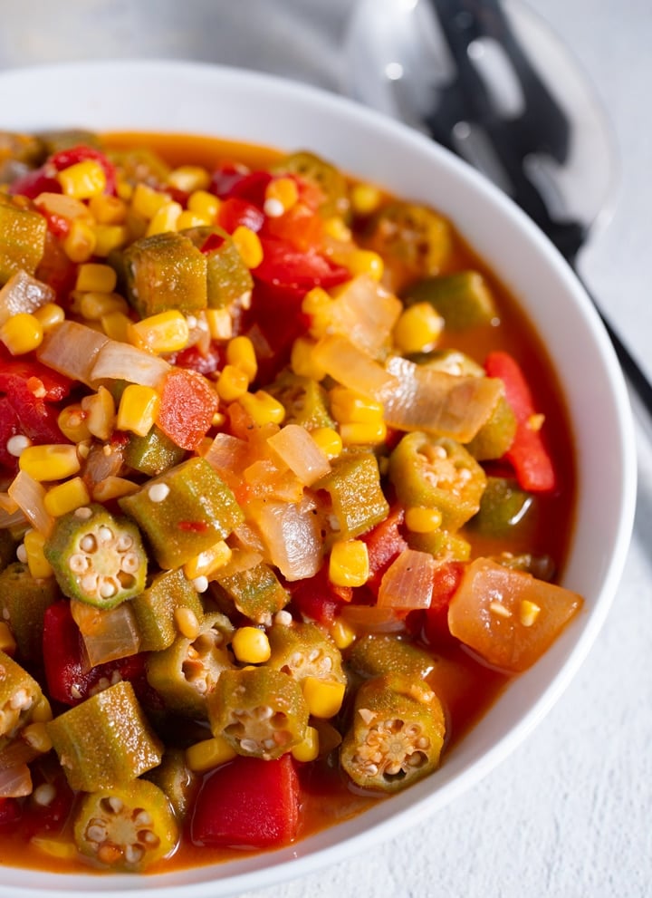 Stewd okra and tomatoes in a white bowl