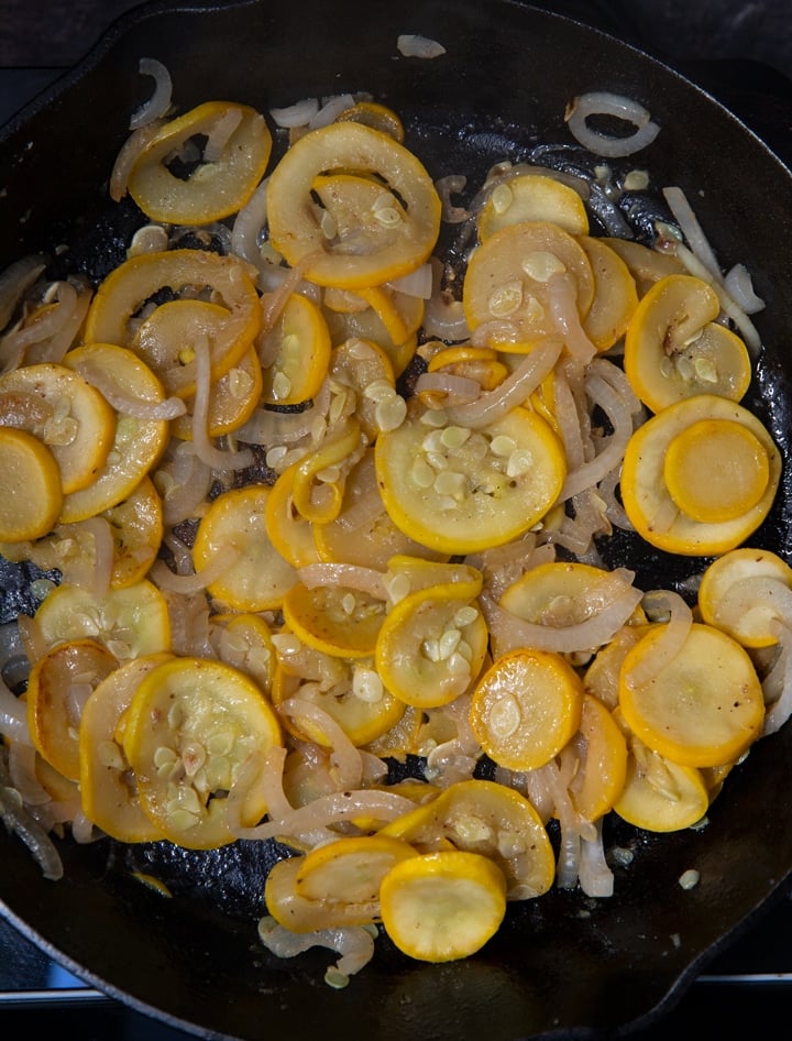 Cooked yellow squash and onions in a skillet