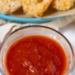 cocktail sauce in bowl with shrimp in background