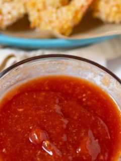 cocktail sauce in bowl with shrimp in background