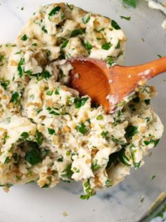 garlic herb butter with wooden spoon in glass bowl