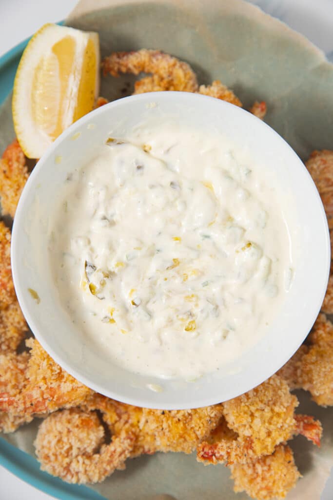 Tartar sauce in a bowl next to shrimp and a lemon wedge