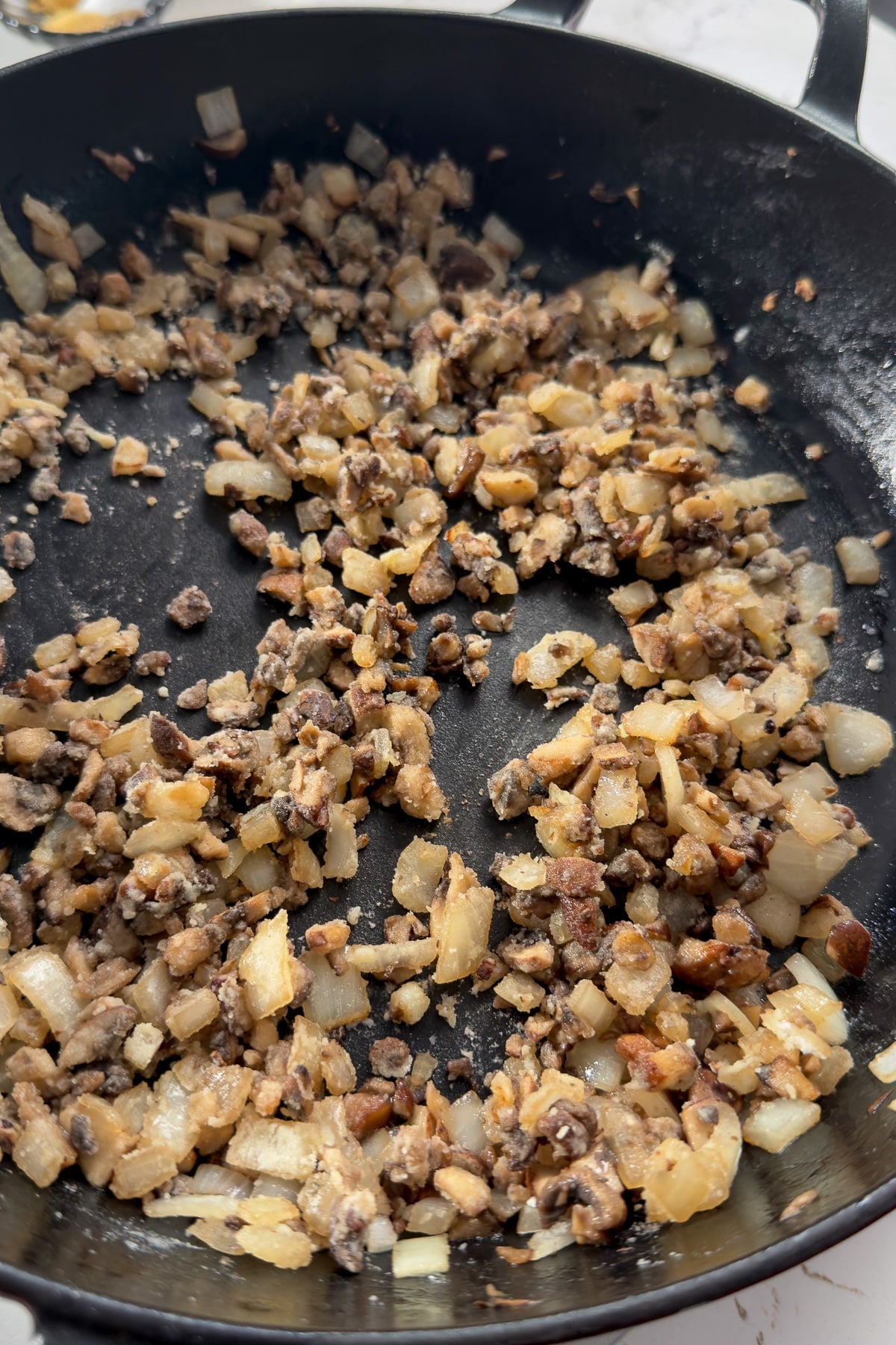 onions and mushrooms in a skillet with flour sprinkled over and stirred