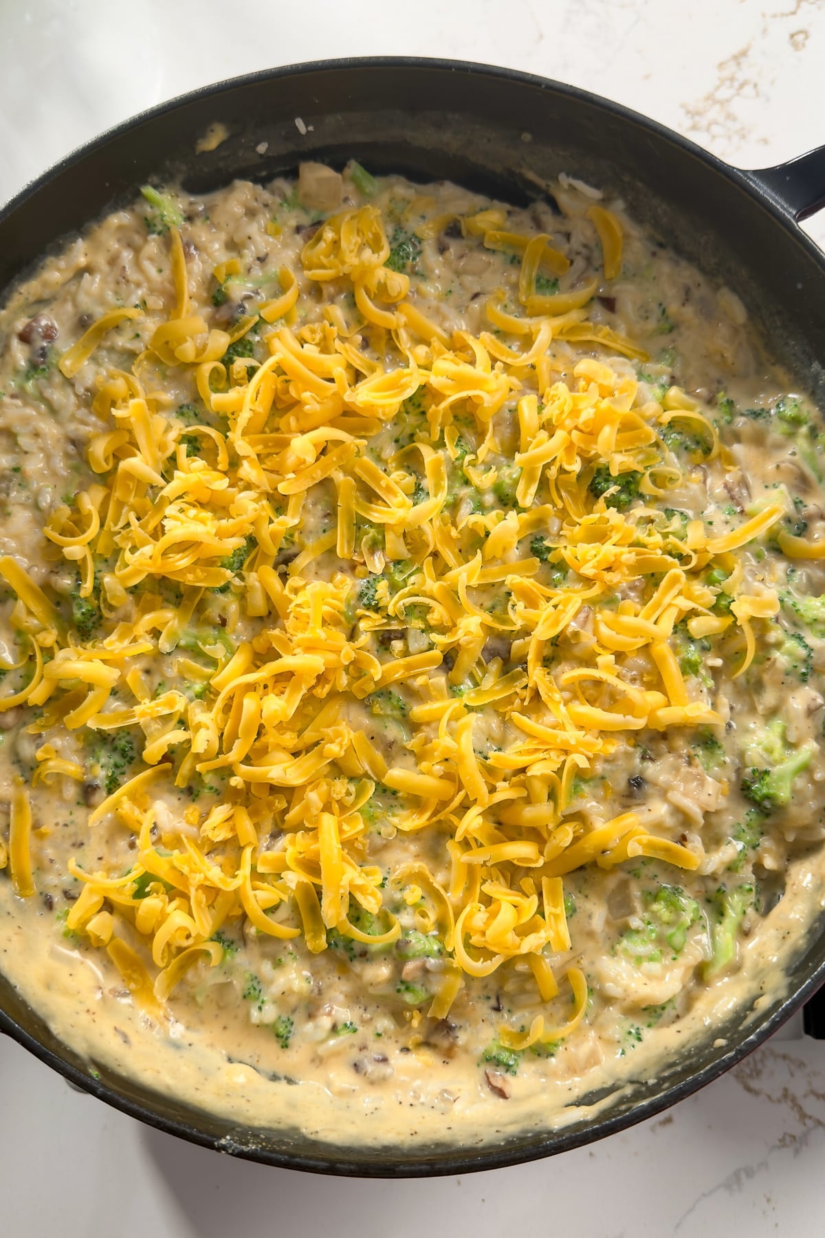 rice, broccoli, chese added to cream sauce in skillet