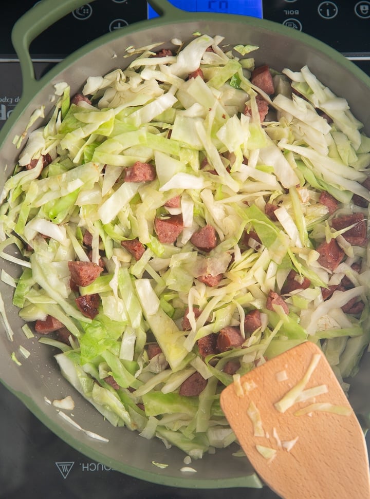Stirring the cabbage into the sausage