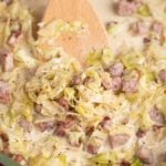 creamed cabbage in skillet with spatula moving the food