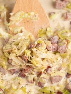 creamed cabbage in skillet with spatula moving the food