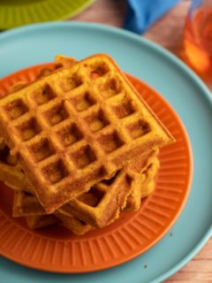 Pumpkin waffles stacked on a plate