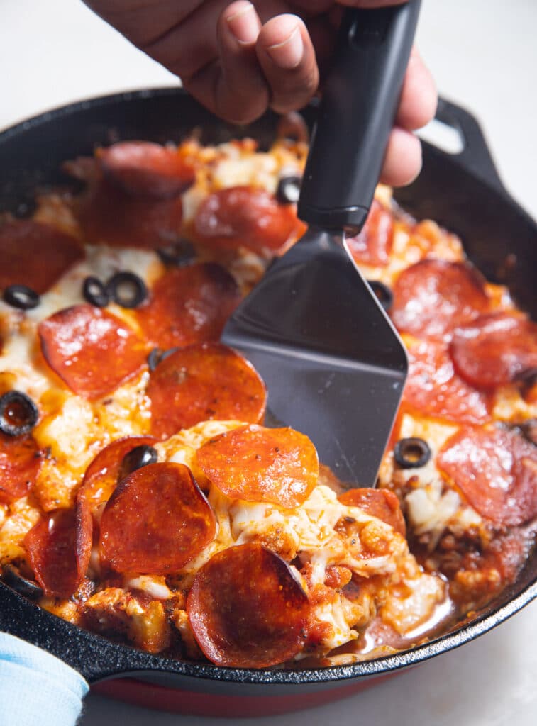 The cauliflower pizza casserole being served out of the skillet.