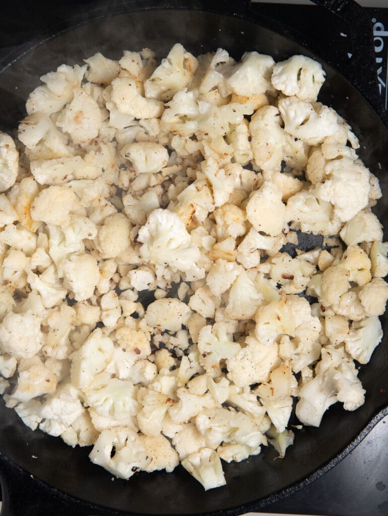 Cooking the cauliflower in the skillet.