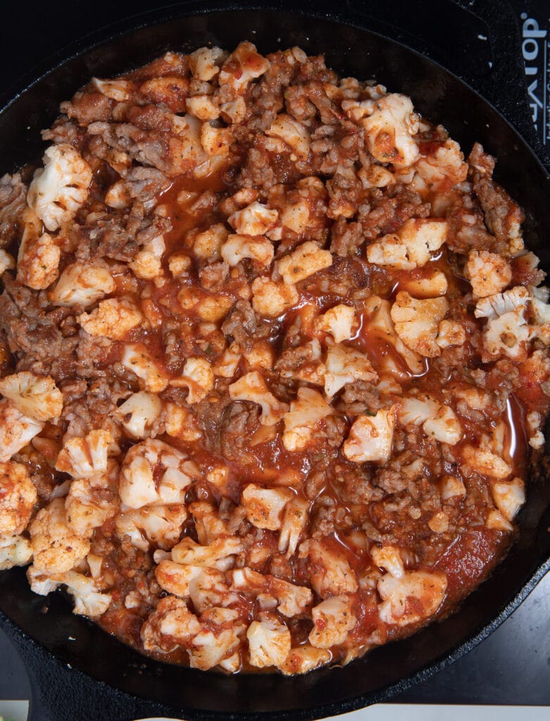 Cauliflower added to the browned sausage.