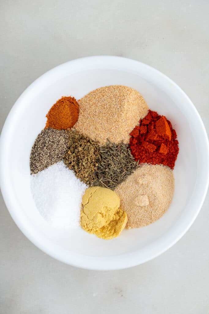 The spices for the seasoning in a white bowl