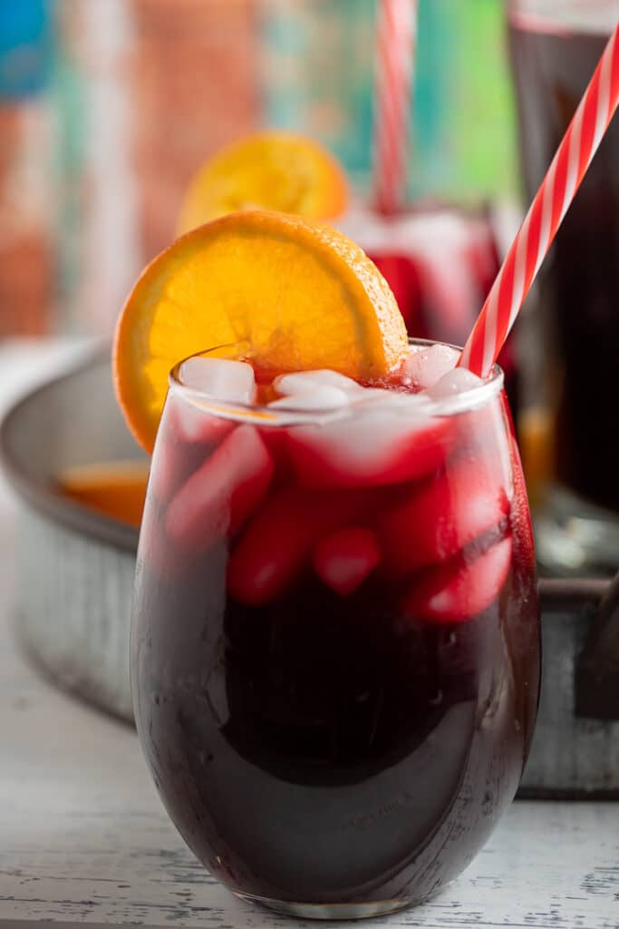 An orange slice garnishing a glass of Jamaican sorrel drink