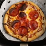 The cooked pizza in the air fryer basket.