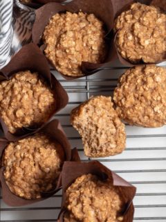 Seven applesauce muffins on a wire rack.