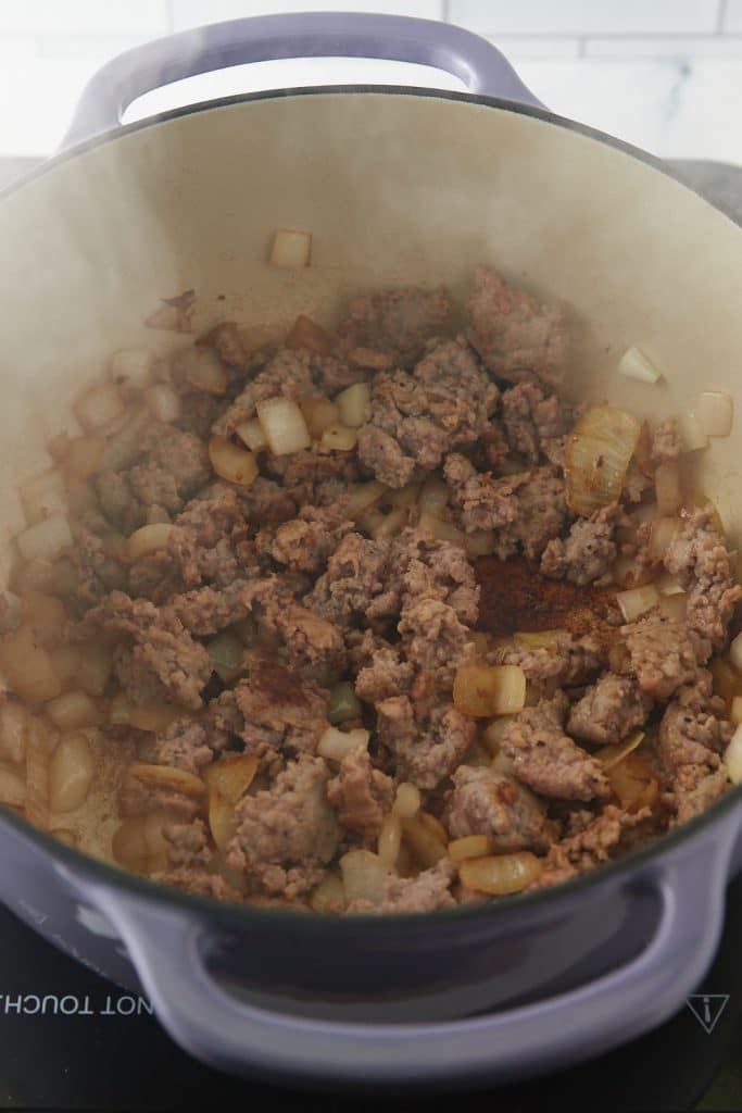 Browning the sausage and onions in a dutch oven.