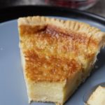 A slice of chess pie on a blue plate.