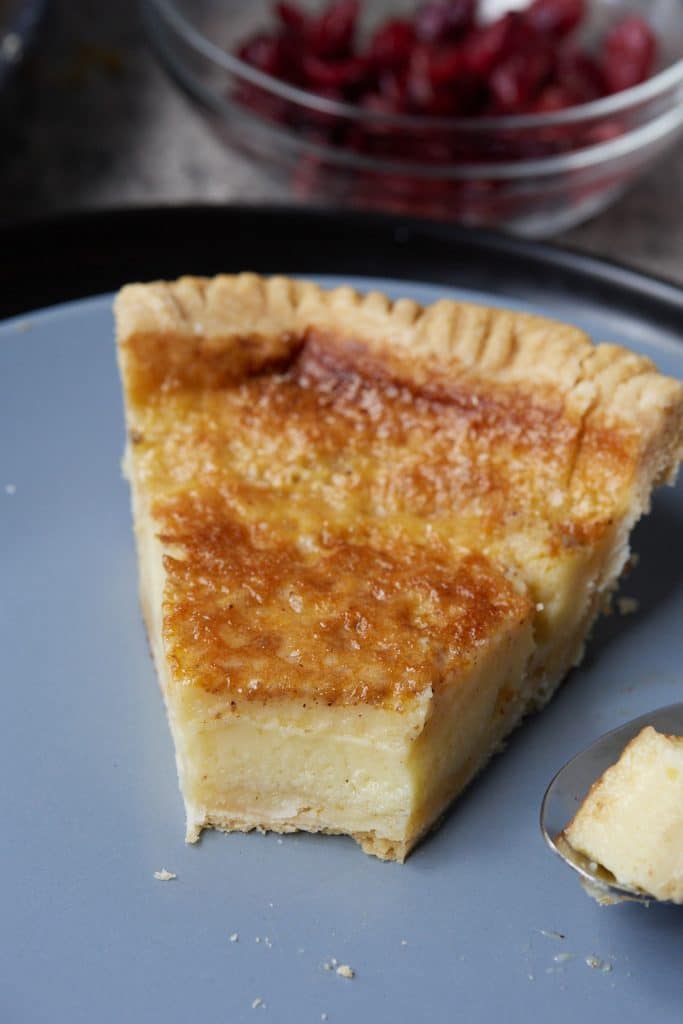 A slice of chess pie on a blue plate.