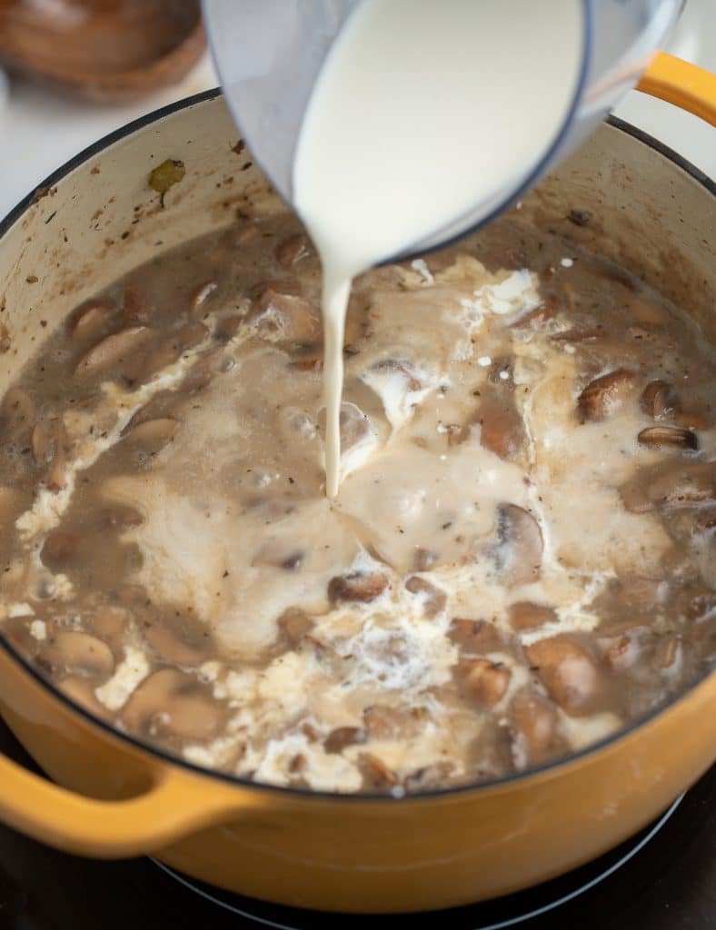 Pouring the cream into the soup.