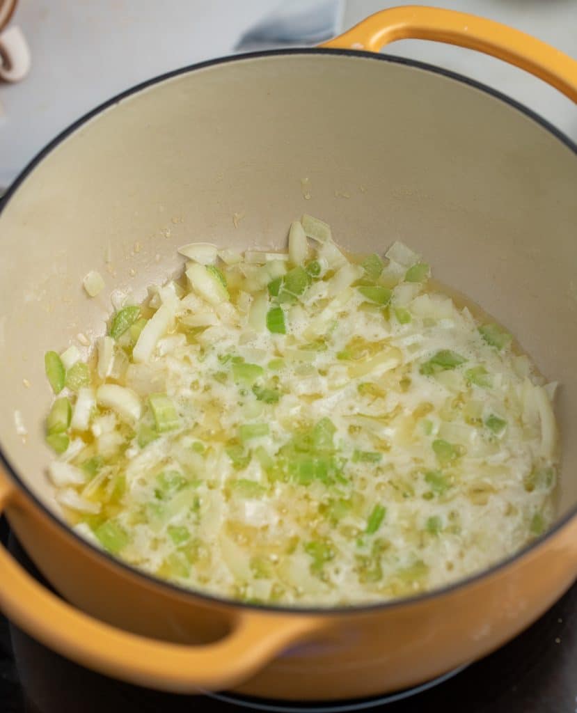 Onion and celery cooking in a pot.
