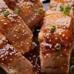 Close up of four pieces of teriyaki salmon.