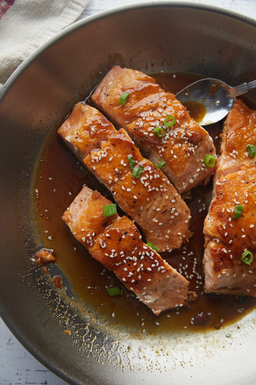 The cooked salmon teriyaki in a skillet.
